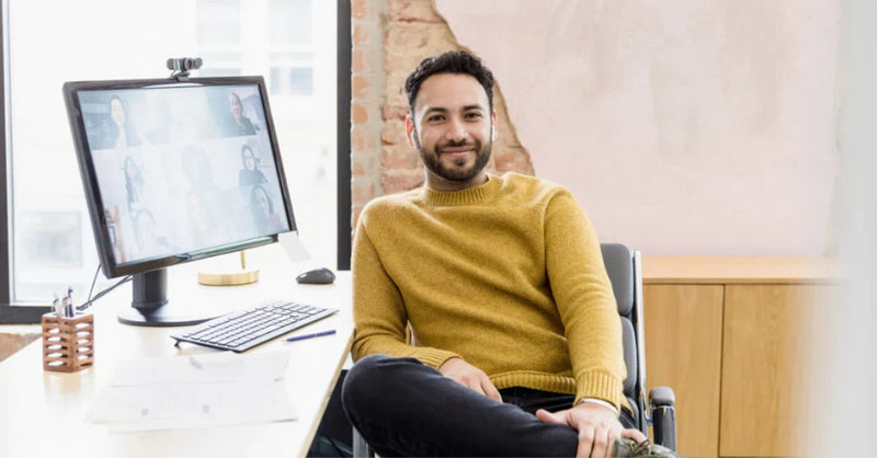 A man smiling while using a webcam for a videoconference