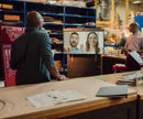 Industrial workspace featuring Neat video conferencing display, with employees remotely collaborating via a virtual meeting, improving communication and productivity in a manufacturing environment